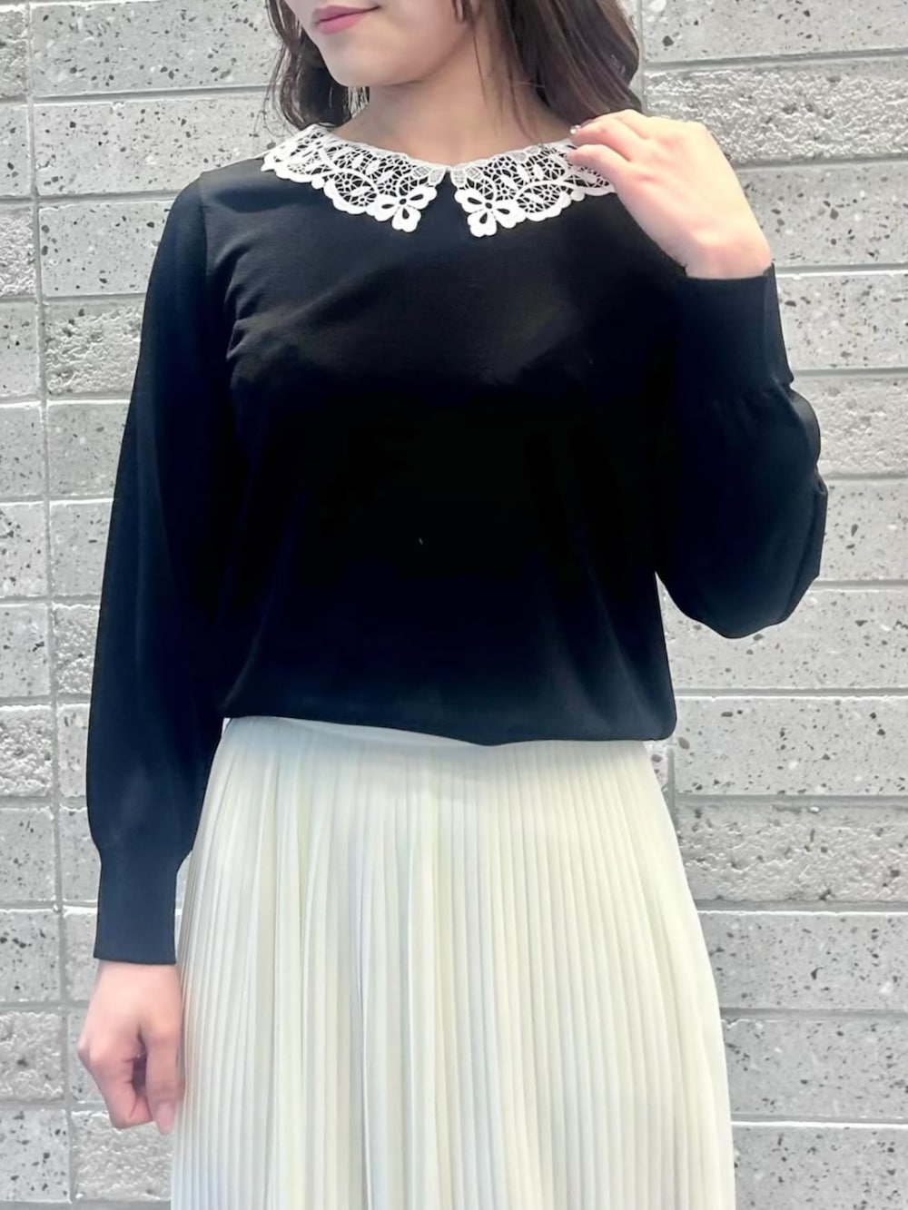 ホワイト系のスカート、ブラック系のニット/セーターを着用したレディースの冬コーディネートの2枚目の写真