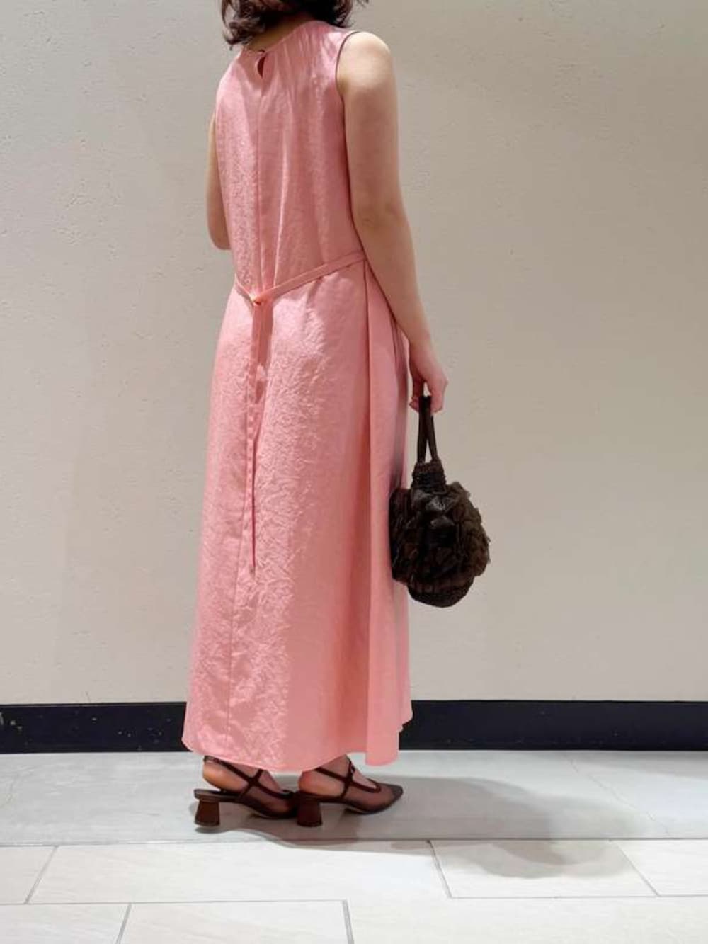 ピンク系のワンピースを着用したレディースの春コーディネートの2枚目の写真