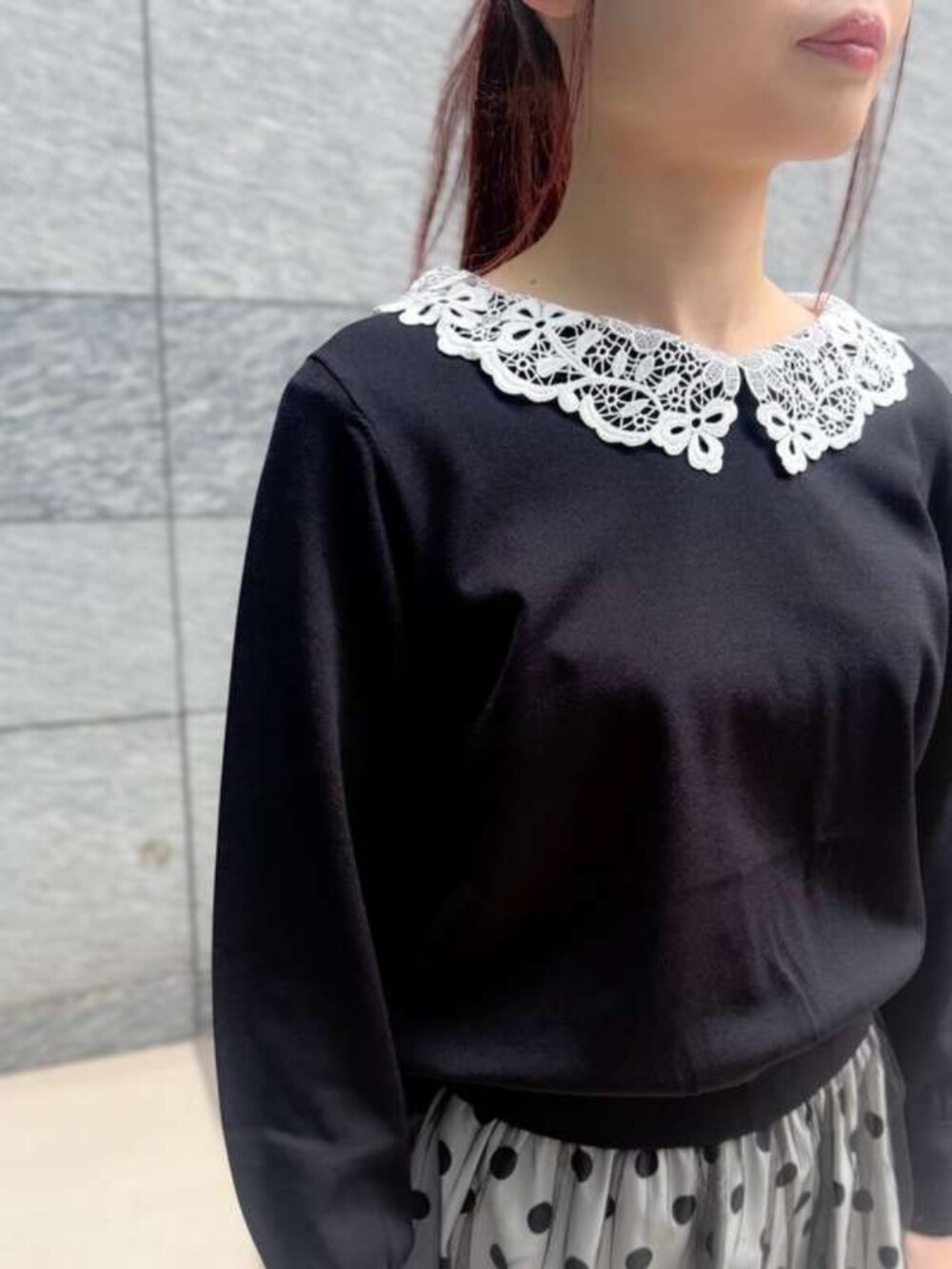 ブラック系のニット/セーター、ホワイト系のスカートを着用したレディースの春コーディネートの2枚目の写真