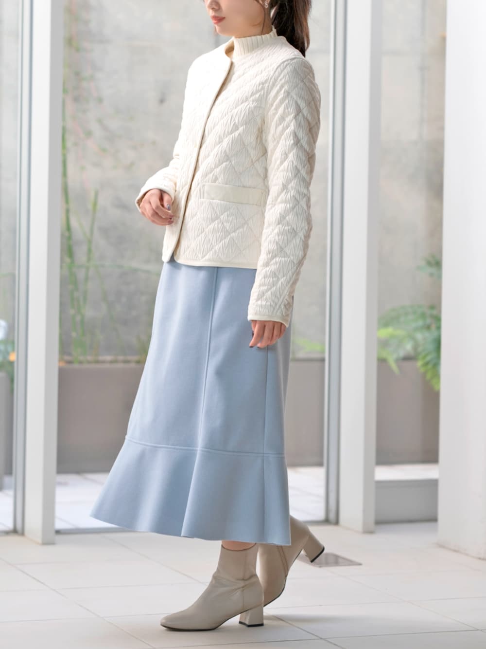 ホワイト系のその他アウター、ブルー系のスカートを着用したレディースの冬コーディネートの2枚目の写真