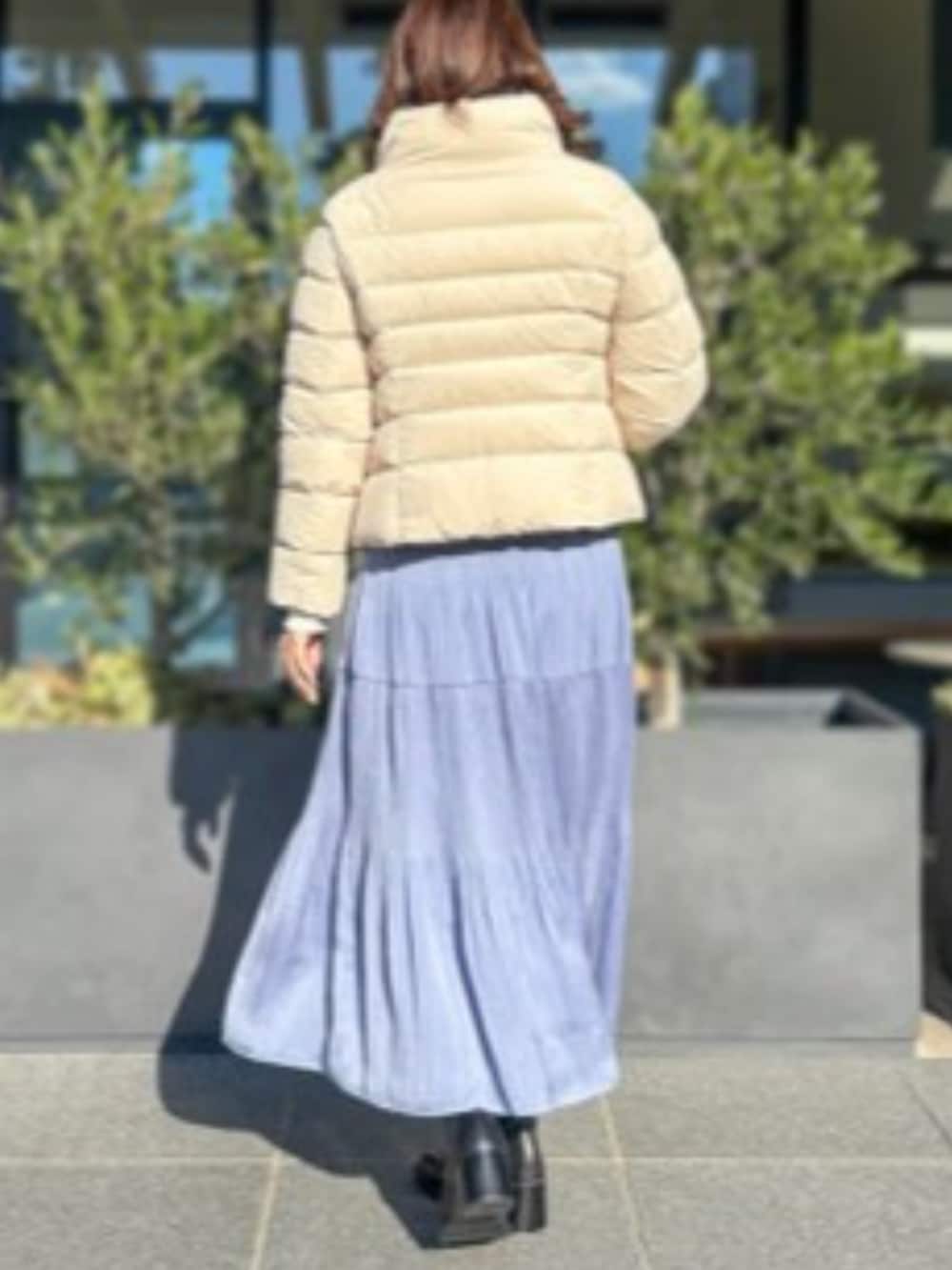 ブルー系のスカート、ベージュ系のダウンジャケット/コートを着用したレディースの冬コーディネートの2枚目の写真