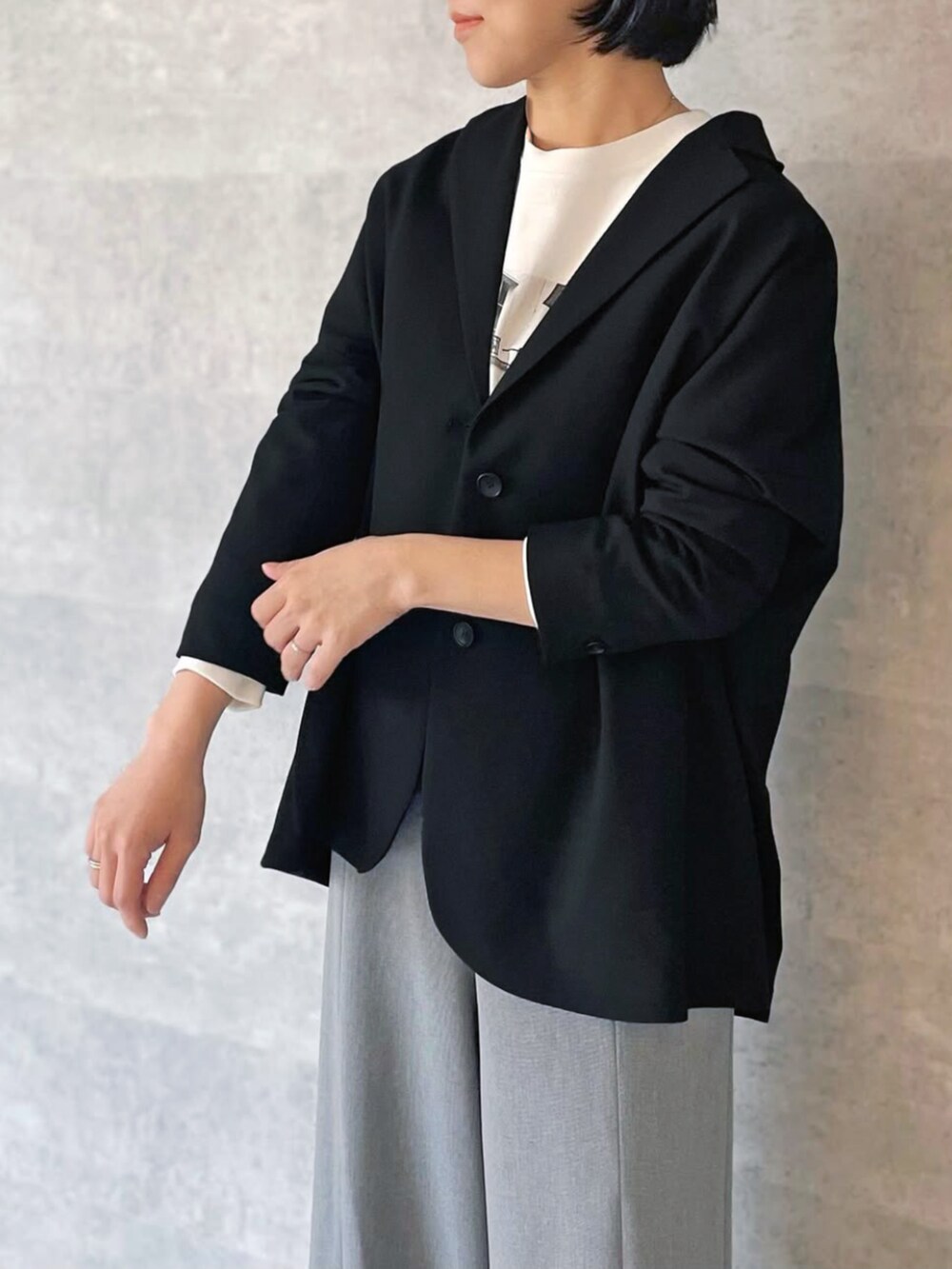 ブラック系のテーラードジャケット、グレー系のスラックスを着用したレディースの秋コーディネートの2枚目の写真