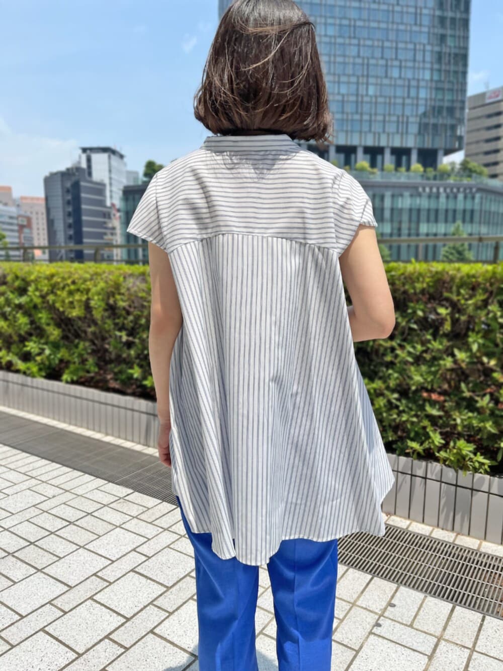 ブルー系のその他パンツ、ホワイト系のシャツ/ブラウスを着用したレディースの夏コーディネートの3枚目の写真