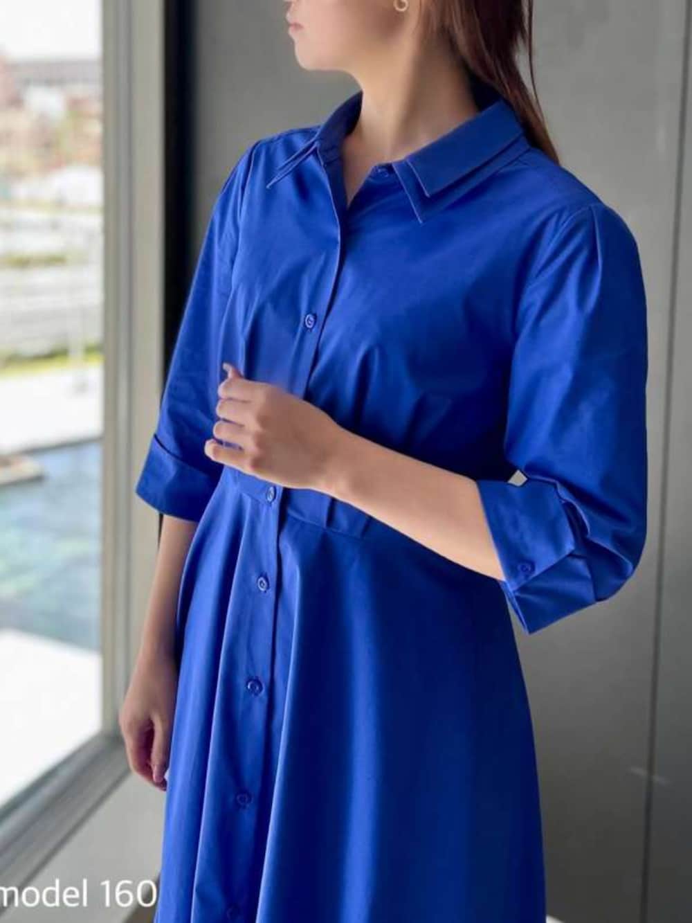 ブルー系のシャツワンピースを着用したレディースの春コーディネートの2枚目の写真