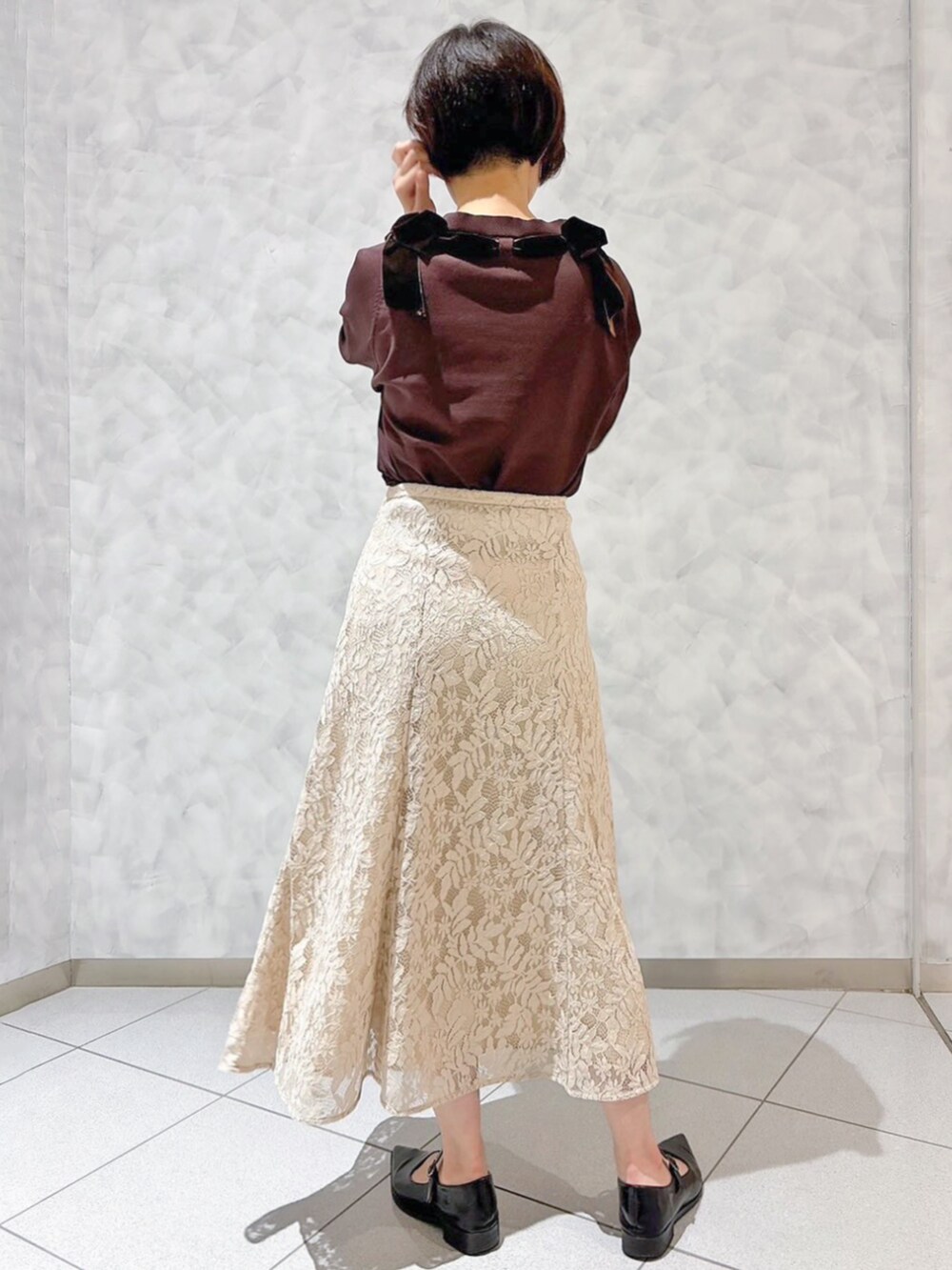 ベージュ系のスカートを着用したレディースの秋コーディネートの3枚目の写真