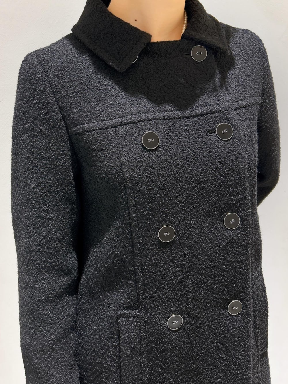 ブラック系のステンカラーコートを着用したレディースの秋コーディネートの4枚目の写真