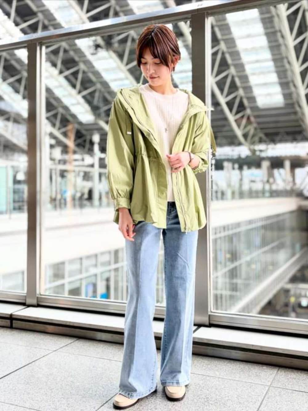 グリーン系のマウンテンパーカーを着用したレディースの冬コーディネートの2枚目の写真