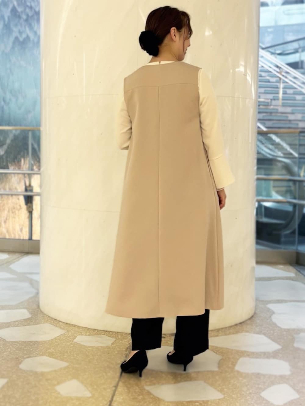 ホワイト系のシャツ/ブラウス、ベージュ系のジャンパースカート、ブラック系のスラックスを着用したレディースの冬コーディネートの2枚目の写真
