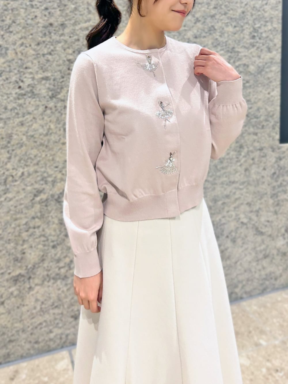 ピンク系のカーディガン/ボレロ、ベージュ系のスカートを着用したレディースの冬コーディネートの3枚目の写真