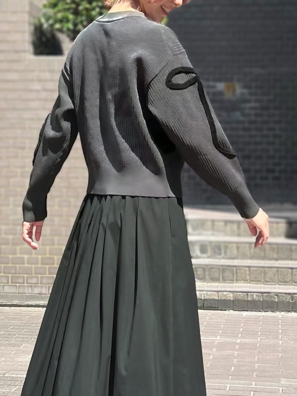 ブラック系のスカートを着用したレディースの秋コーディネートの2枚目の写真