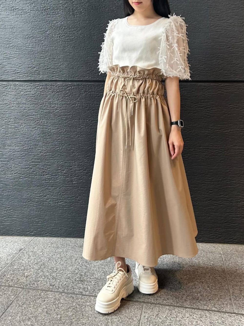 ベージュ系のジャンパースカート、ホワイト系のニット/セーターを着用したレディースの冬コーディネートの4枚目の写真