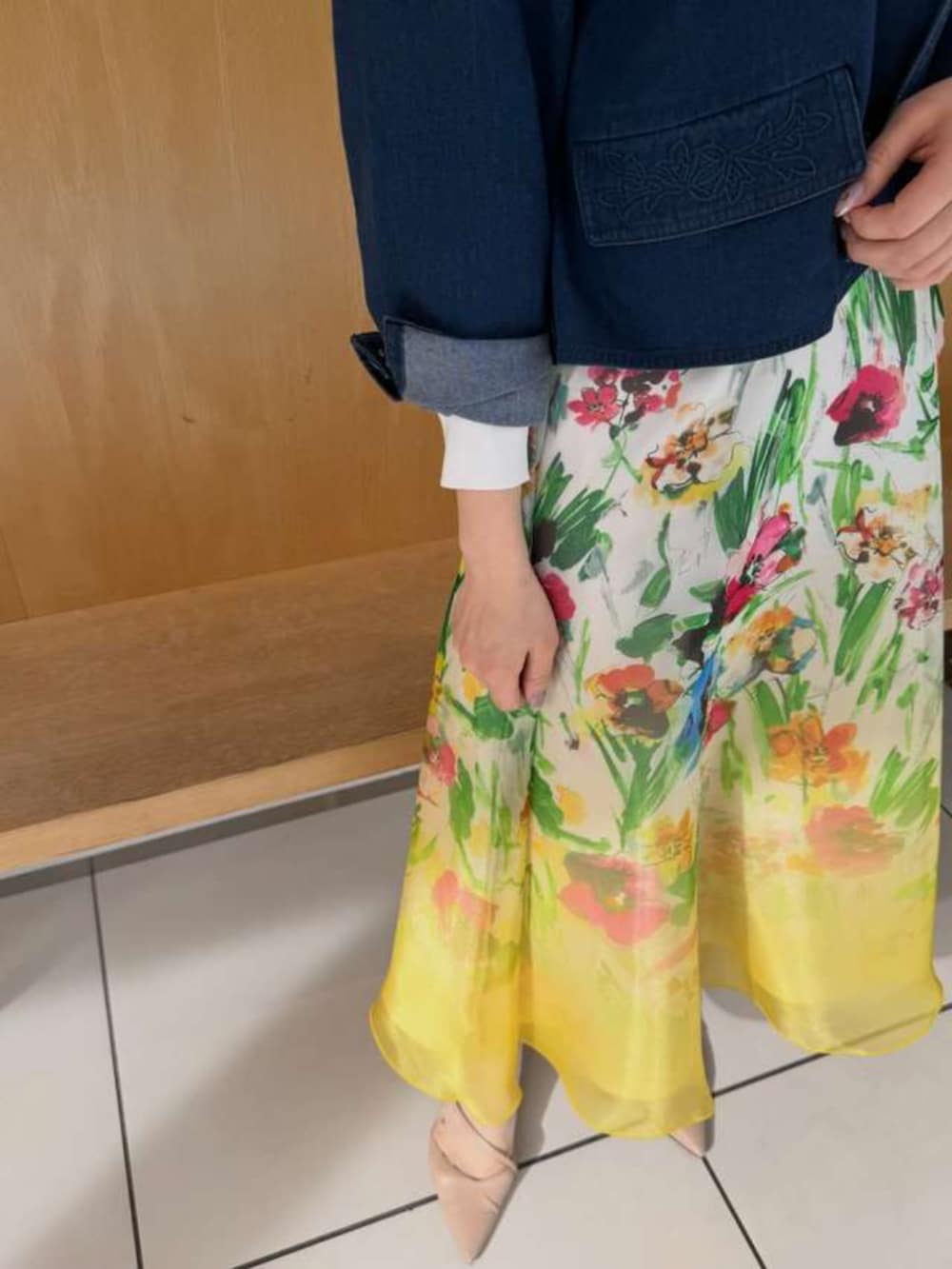 イエロー系のスカート、ブルー系のデニムジャケットを着用したレディースの春コーディネートの2枚目の写真