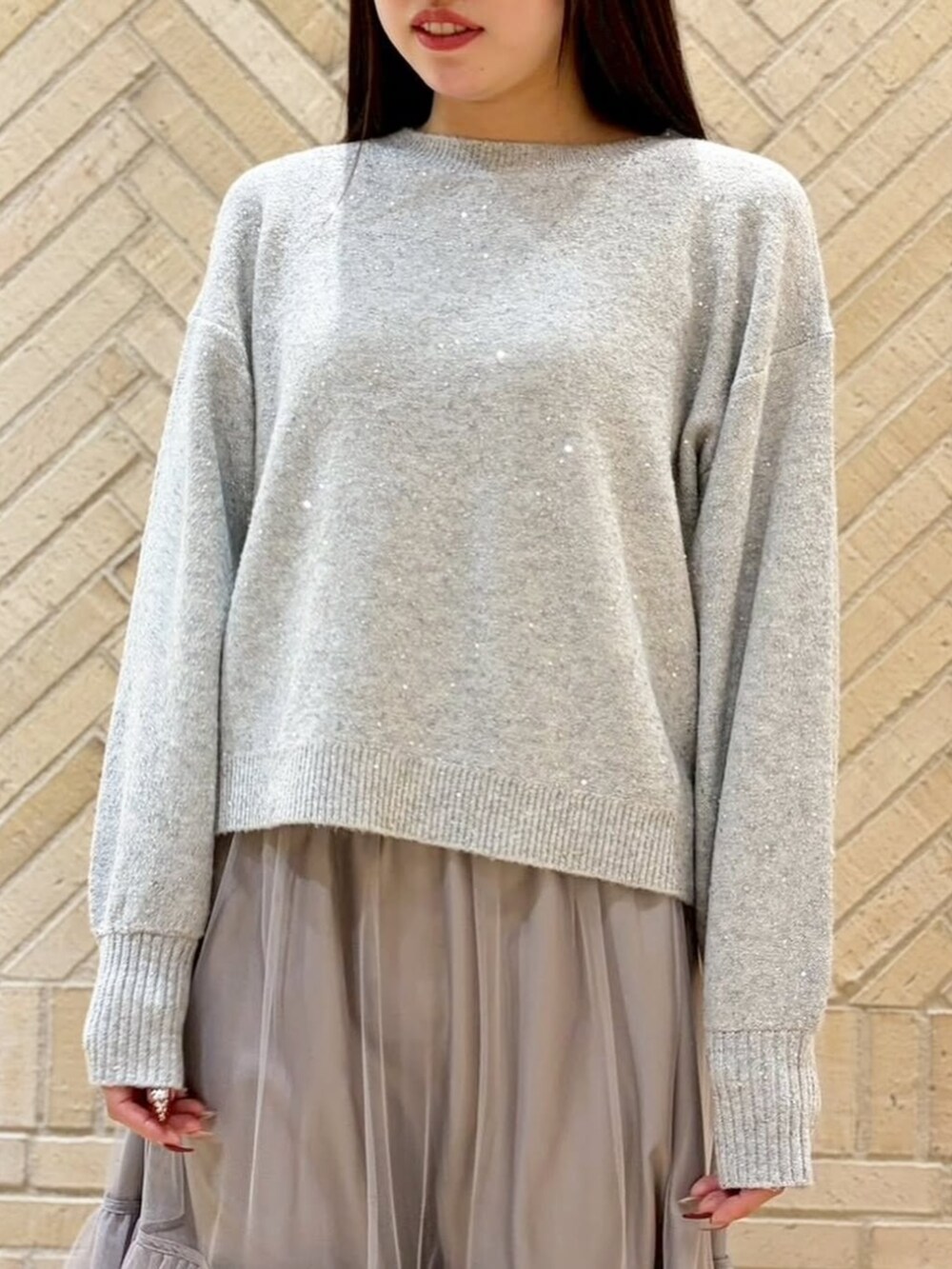 グレー系のスカート、グレー系のニット/セーターを着用したレディースの冬コーディネートの4枚目の写真