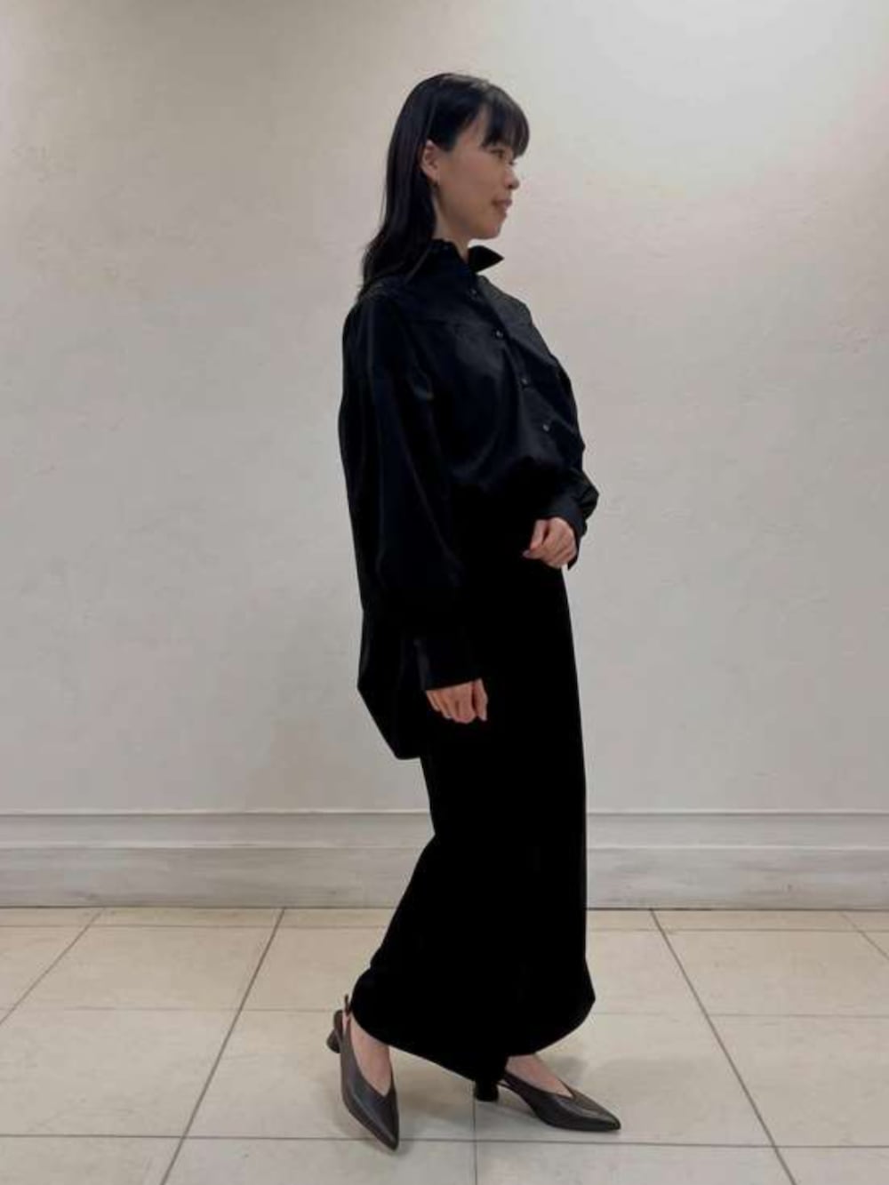 ブラック系のシャツ/ブラウスを着用したレディースの春コーディネートの2枚目の写真