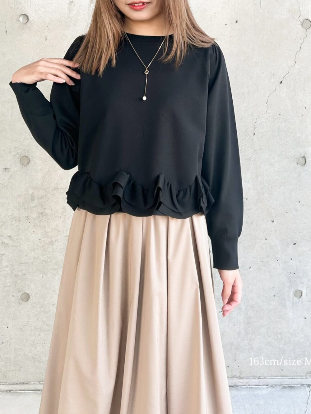 イエロー系のスカート、ブラック系のニット/セーターを着用したレディースの冬コーディネートの3枚目の写真