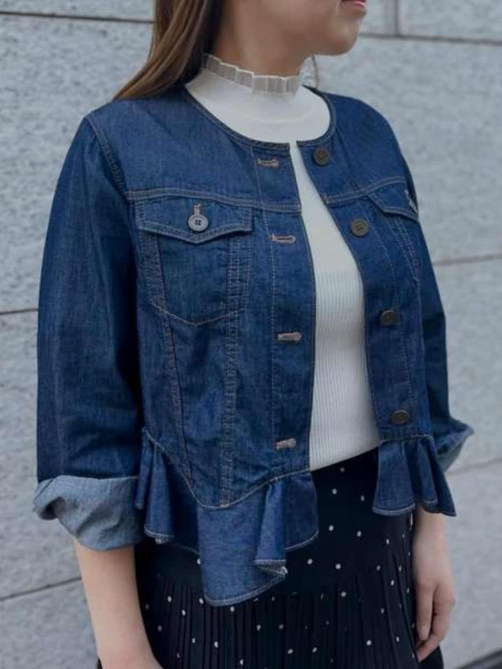 ブルー系のデニムジャケット、ブラック系のスカートを着用したレディースの春コーディネートの2枚目の写真