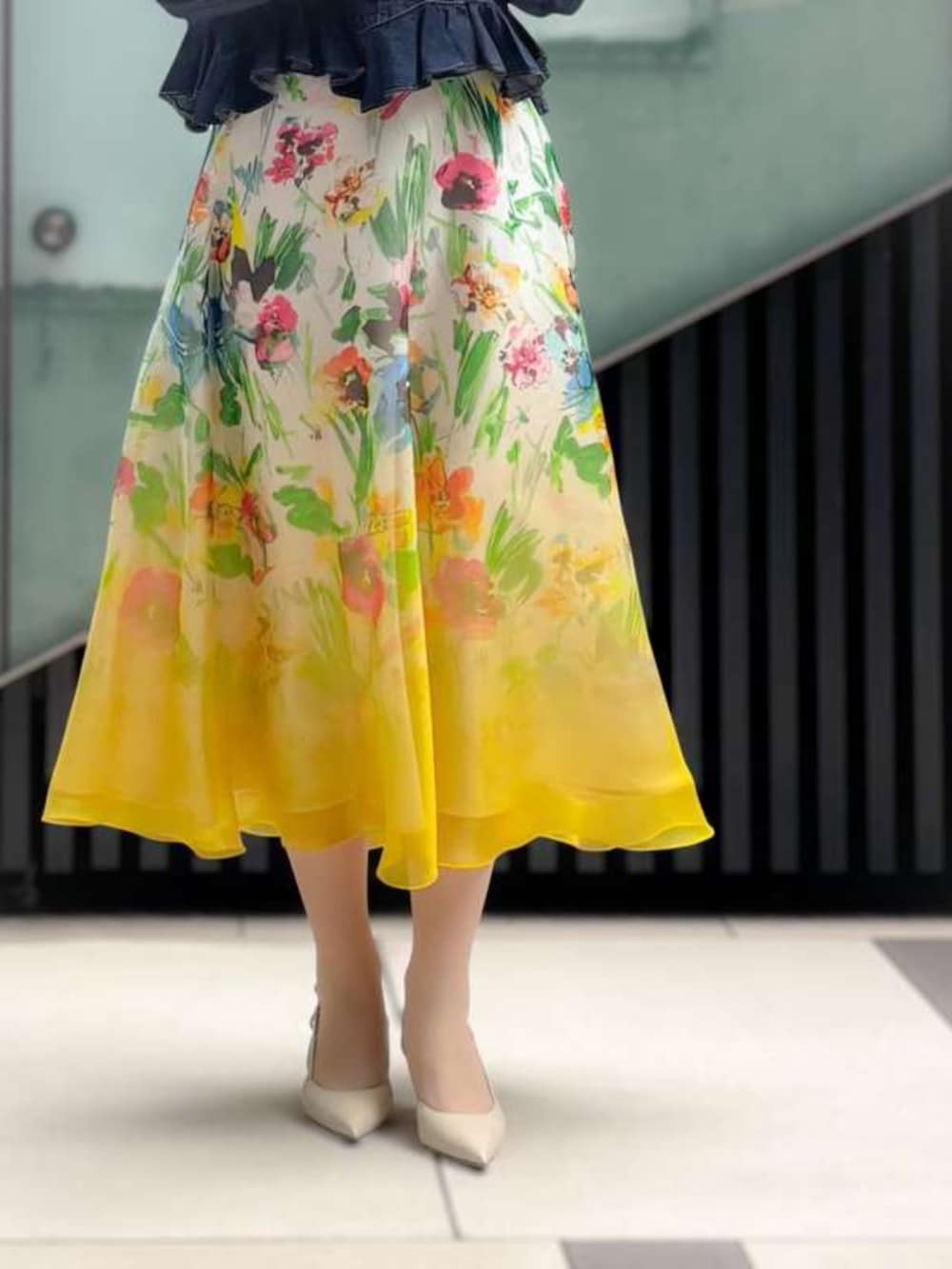 イエロー系のスカート、ブルー系のデニムジャケットを着用したレディースの春コーディネートの3枚目の写真