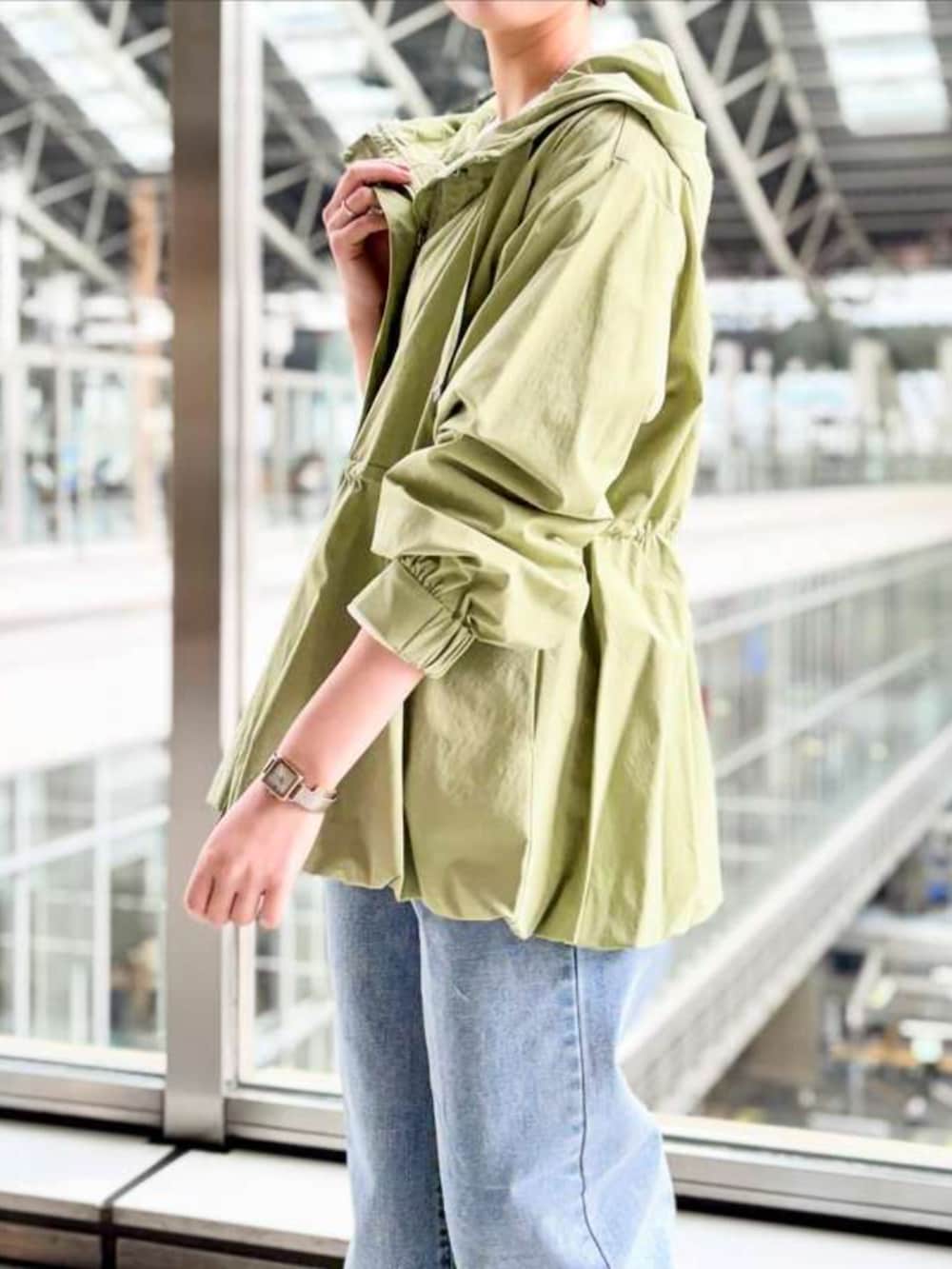 グリーン系のマウンテンパーカーを着用したレディースの冬コーディネートの3枚目の写真