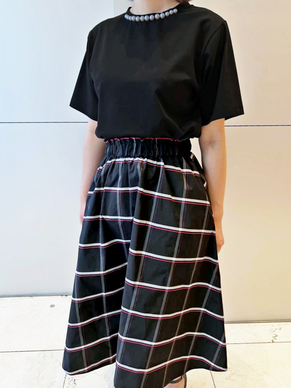 ブラック系のスカート、ブラック系のTシャツ/カットソーを着用したレディースの夏コーディネートの3枚目の写真