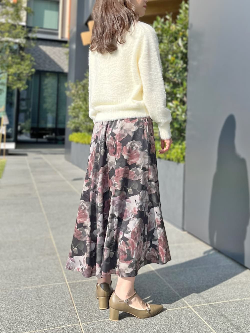 ホワイト系のカーディガン/ボレロ、ブラック系のスカートを着用したレディースの秋コーディネートの3枚目の写真