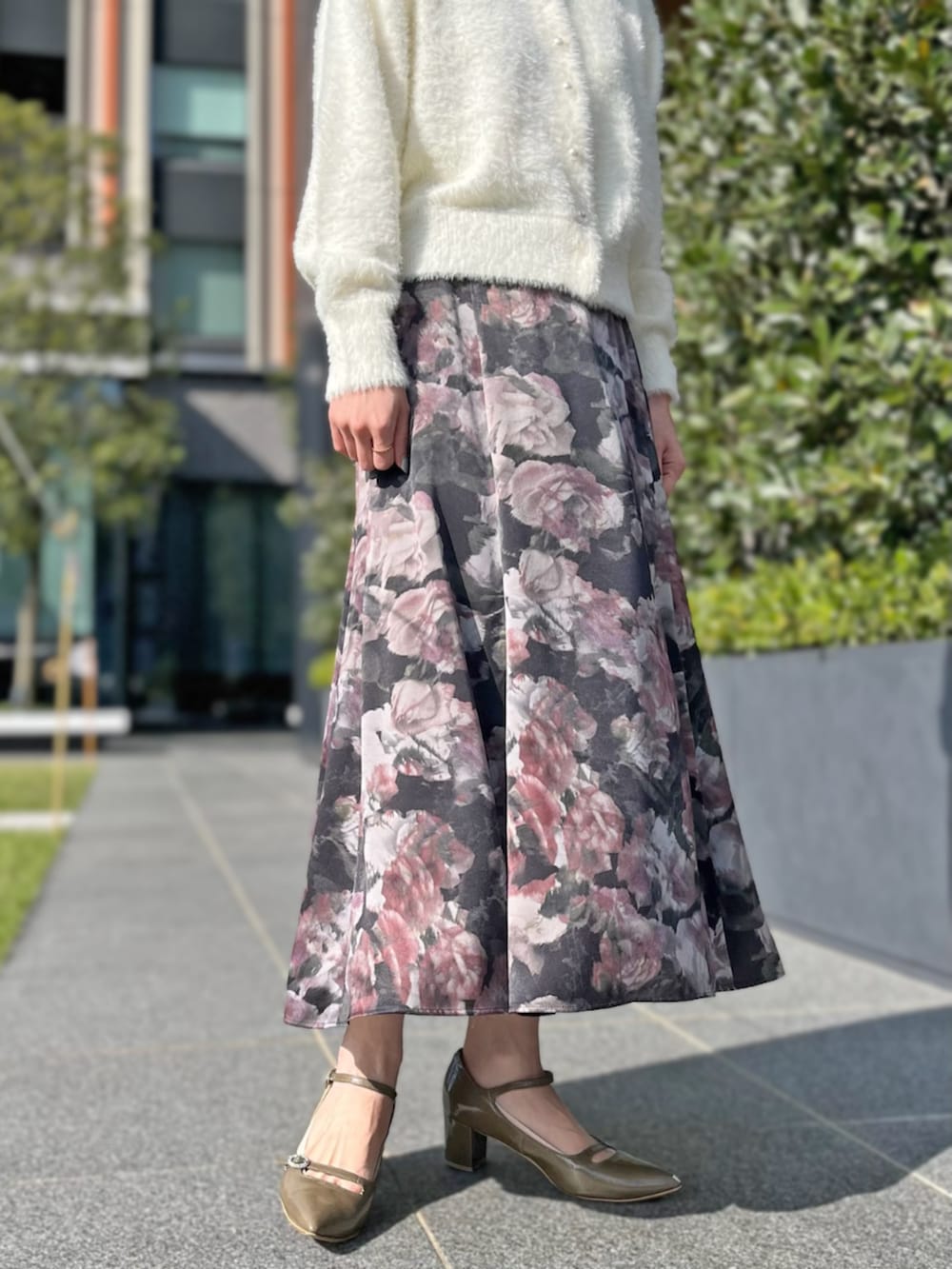 ホワイト系のカーディガン/ボレロ、ブラック系のスカートを着用したレディースの秋コーディネートの2枚目の写真