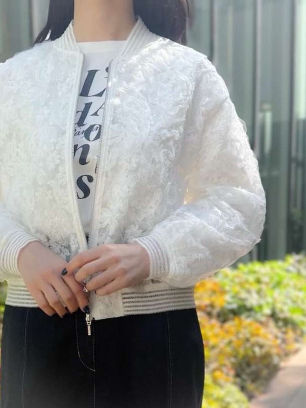 ホワイト系のブルゾン、ブルー系のデニムスカートを着用したレディースの春コーディネートの2枚目の写真