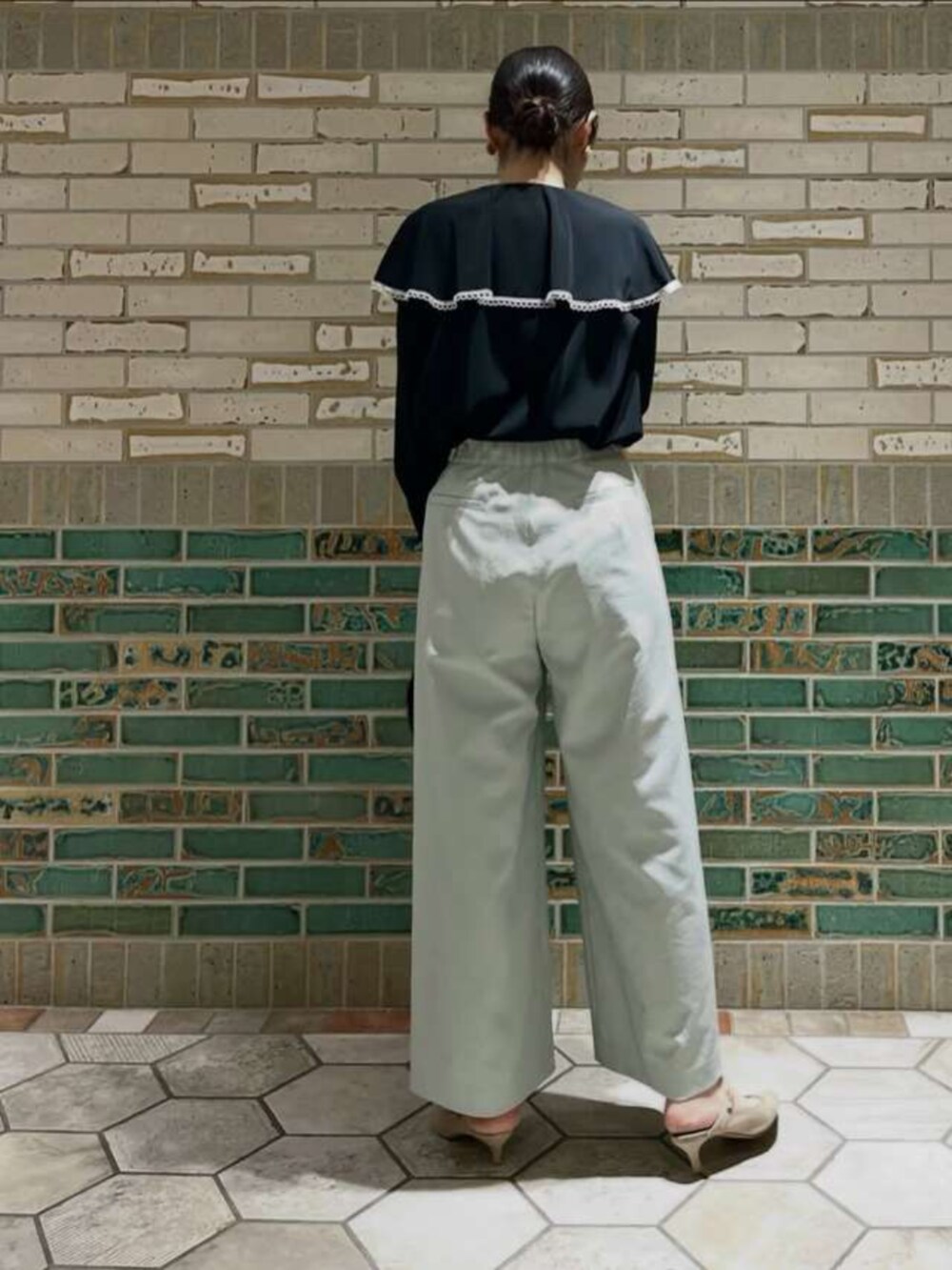 ブラック系のシャツ/ブラウス、グリーン系のスラックスを着用したレディースの春コーディネートの3枚目の写真