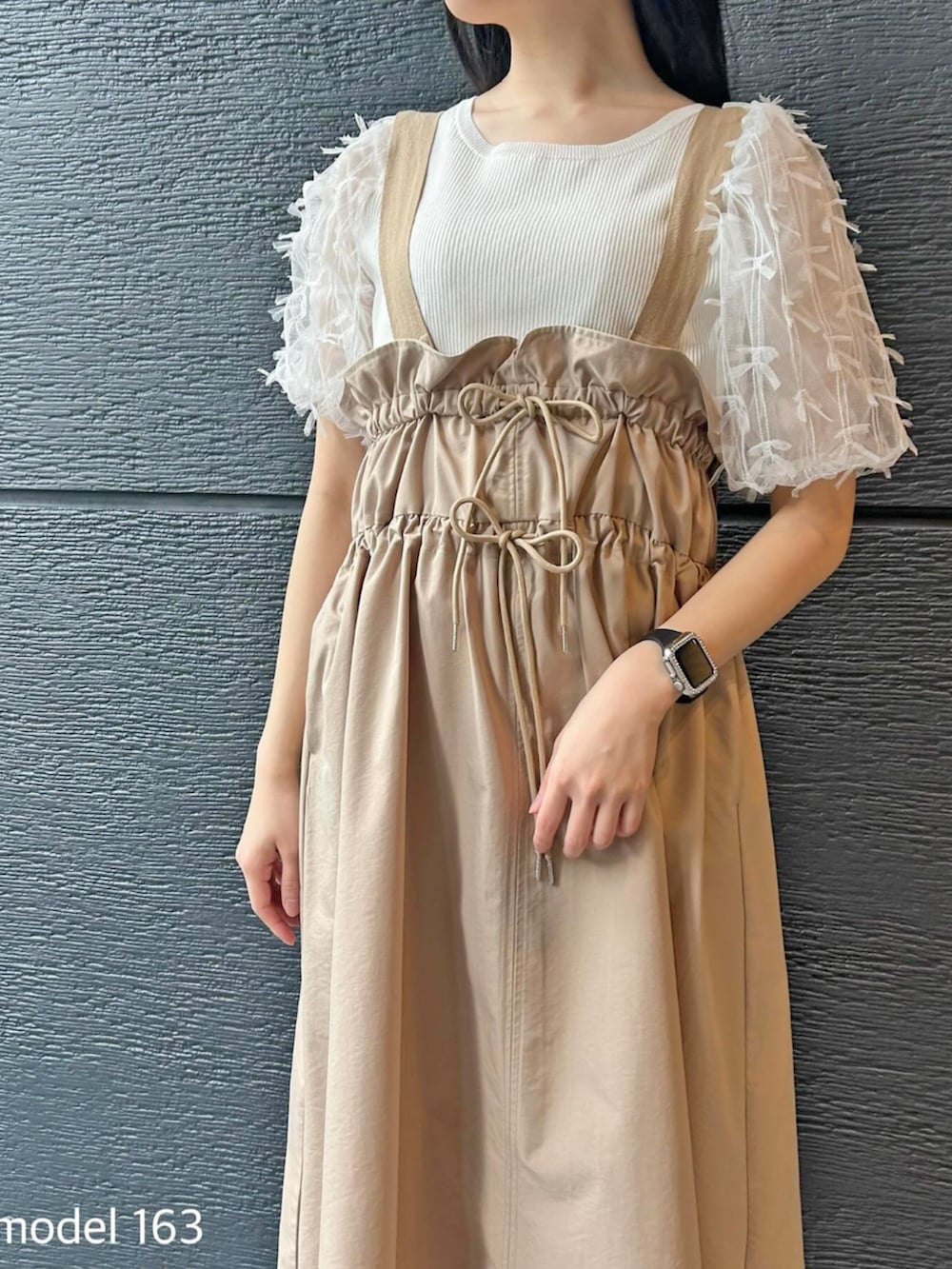 ベージュ系のジャンパースカート、ホワイト系のニット/セーターを着用したレディースの冬コーディネートの3枚目の写真