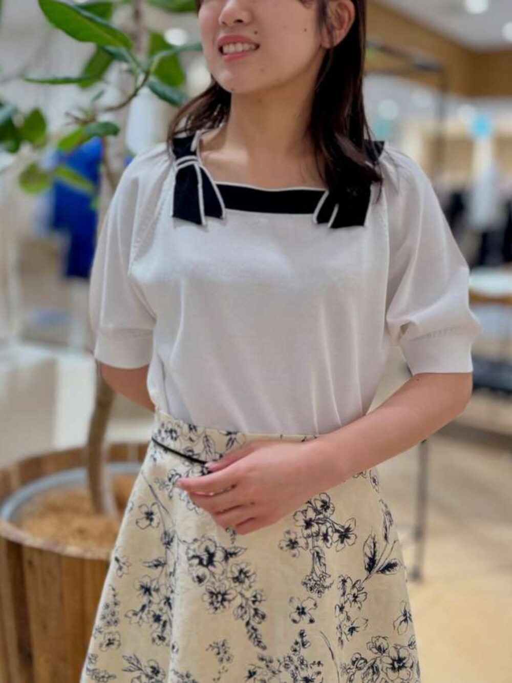 ホワイト系のニット/セーター、ベージュ系のスカートを着用したレディースの春コーディネートの2枚目の写真