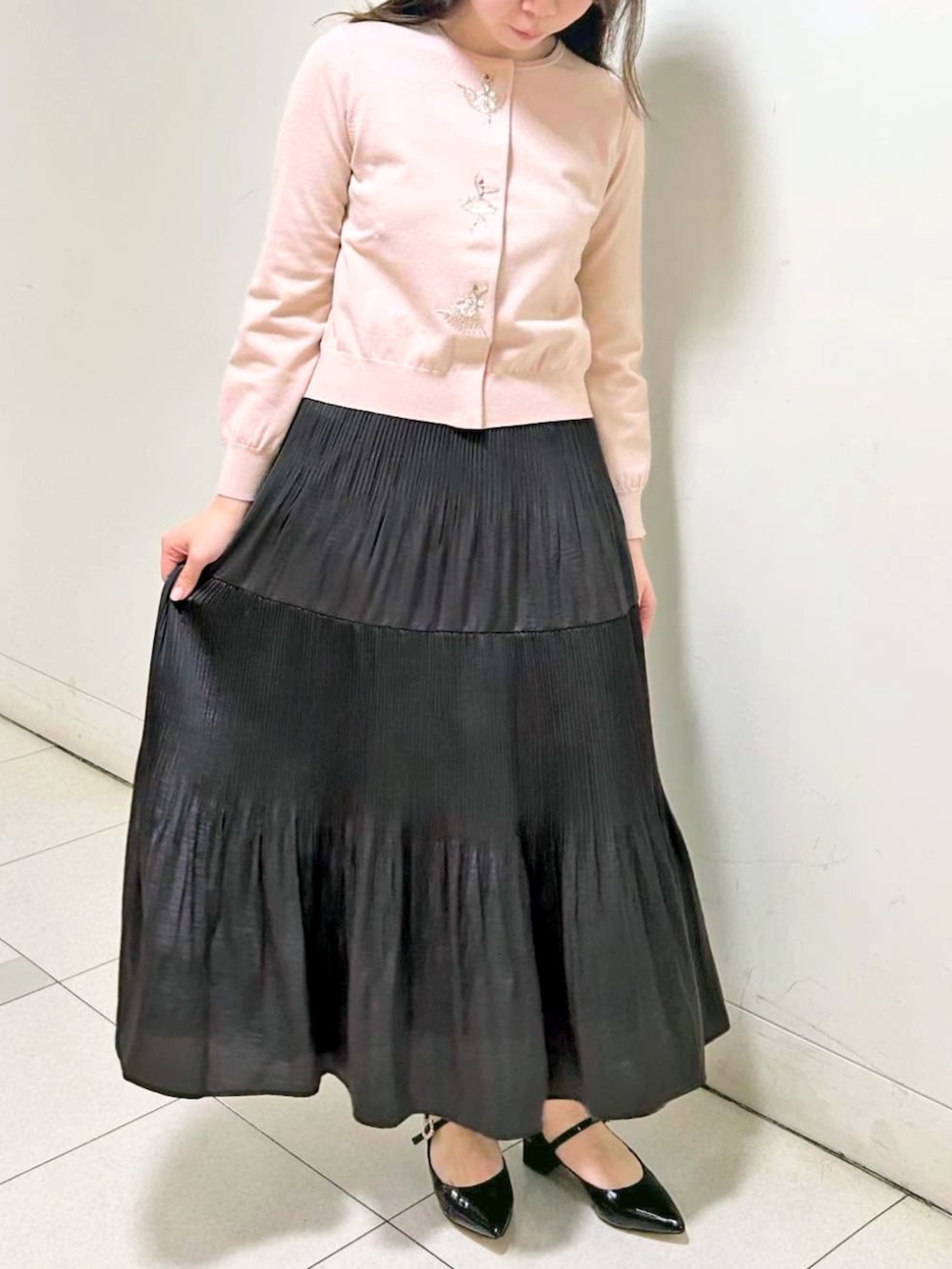 ピンク系のカーディガン/ボレロ、グレー系のスカートを着用したレディースの冬コーディネートの2枚目の写真