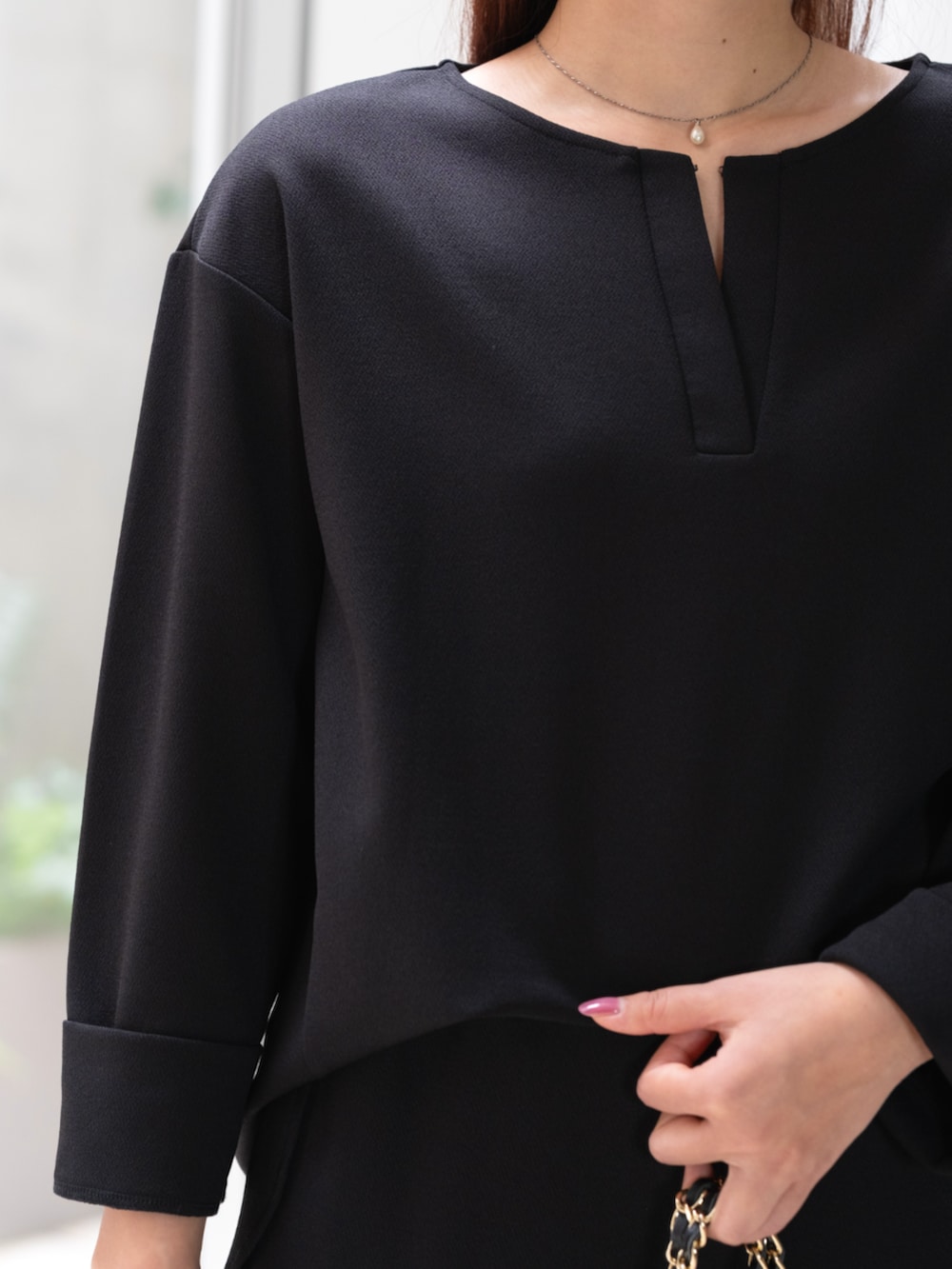 ブラック系のパンツドレスを着用したレディースの秋コーディネートの2枚目の写真