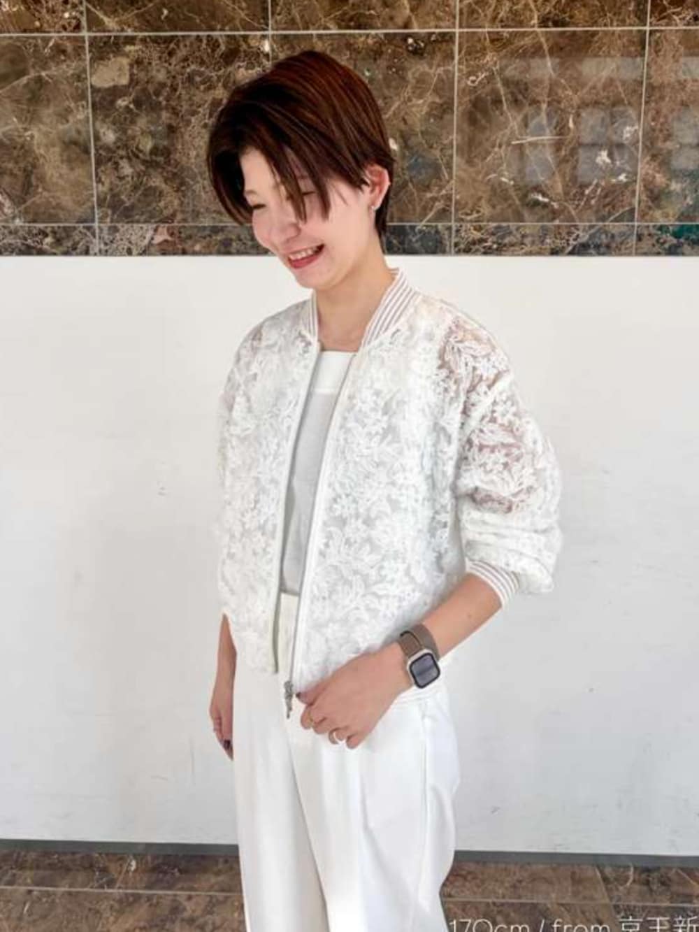 ホワイト系のブルゾン、ホワイト系のスラックスを着用したレディースの春コーディネートの2枚目の写真