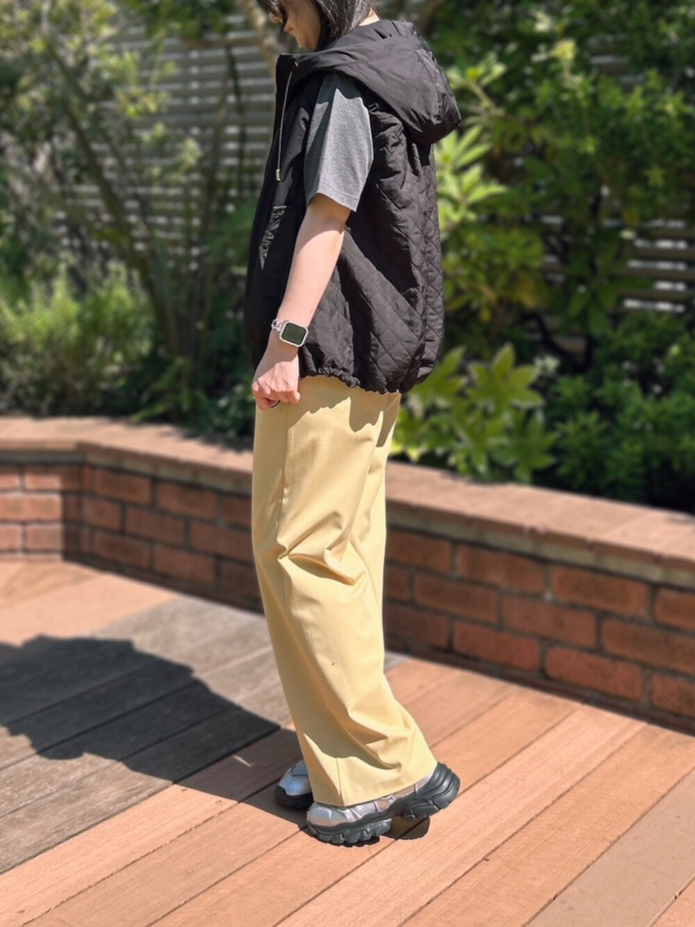 グレー系のTシャツ/カットソー、イエロー系のスラックスを着用したレディースの秋コーディネートの3枚目の写真