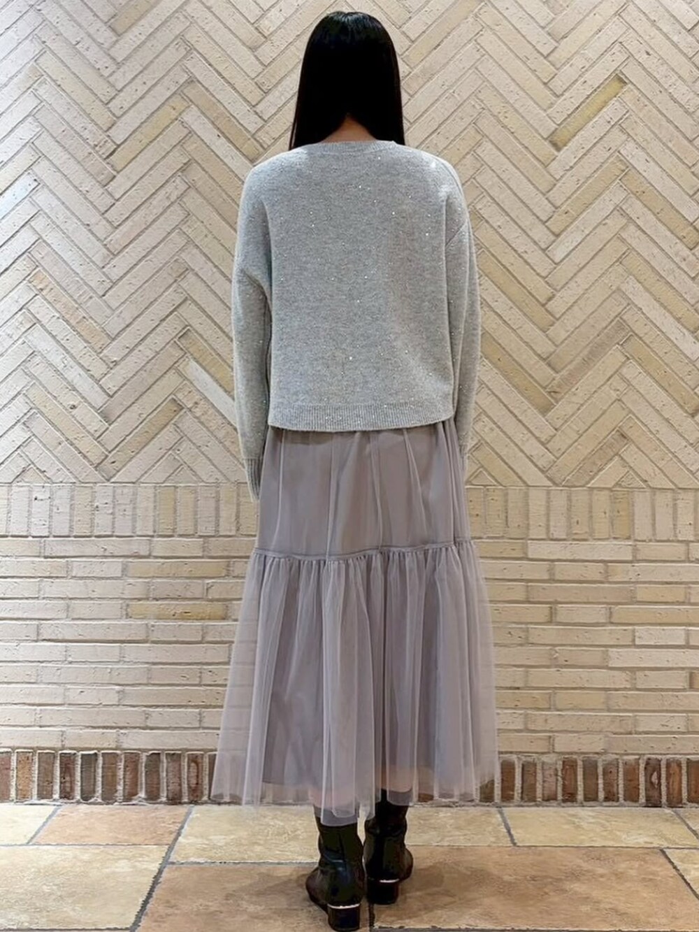 グレー系のスカート、グレー系のニット/セーターを着用したレディースの冬コーディネートの3枚目の写真