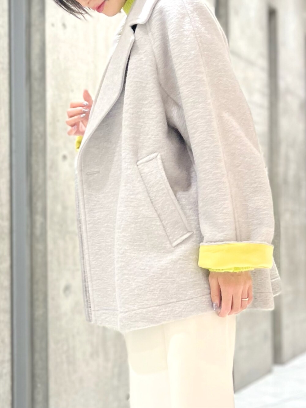 グレー系のその他アウター、イエロー系のニット/セーター、ホワイト系のその他パンツを着用したレディースの秋コーディネートの3枚目の写真