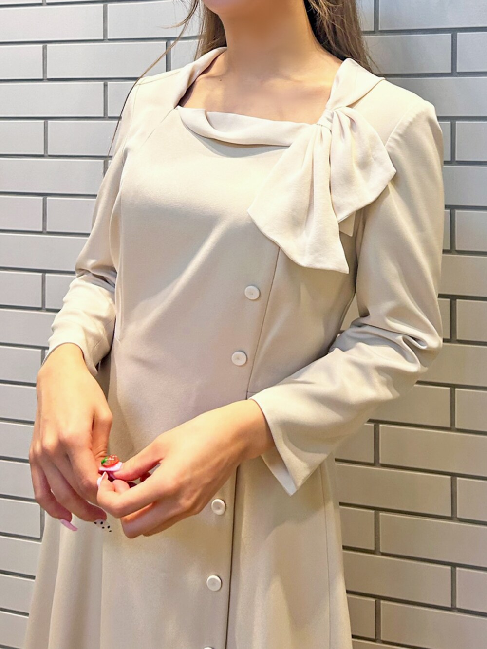 ベージュ系のワンピースを着用したレディースの秋コーディネートの2枚目の写真