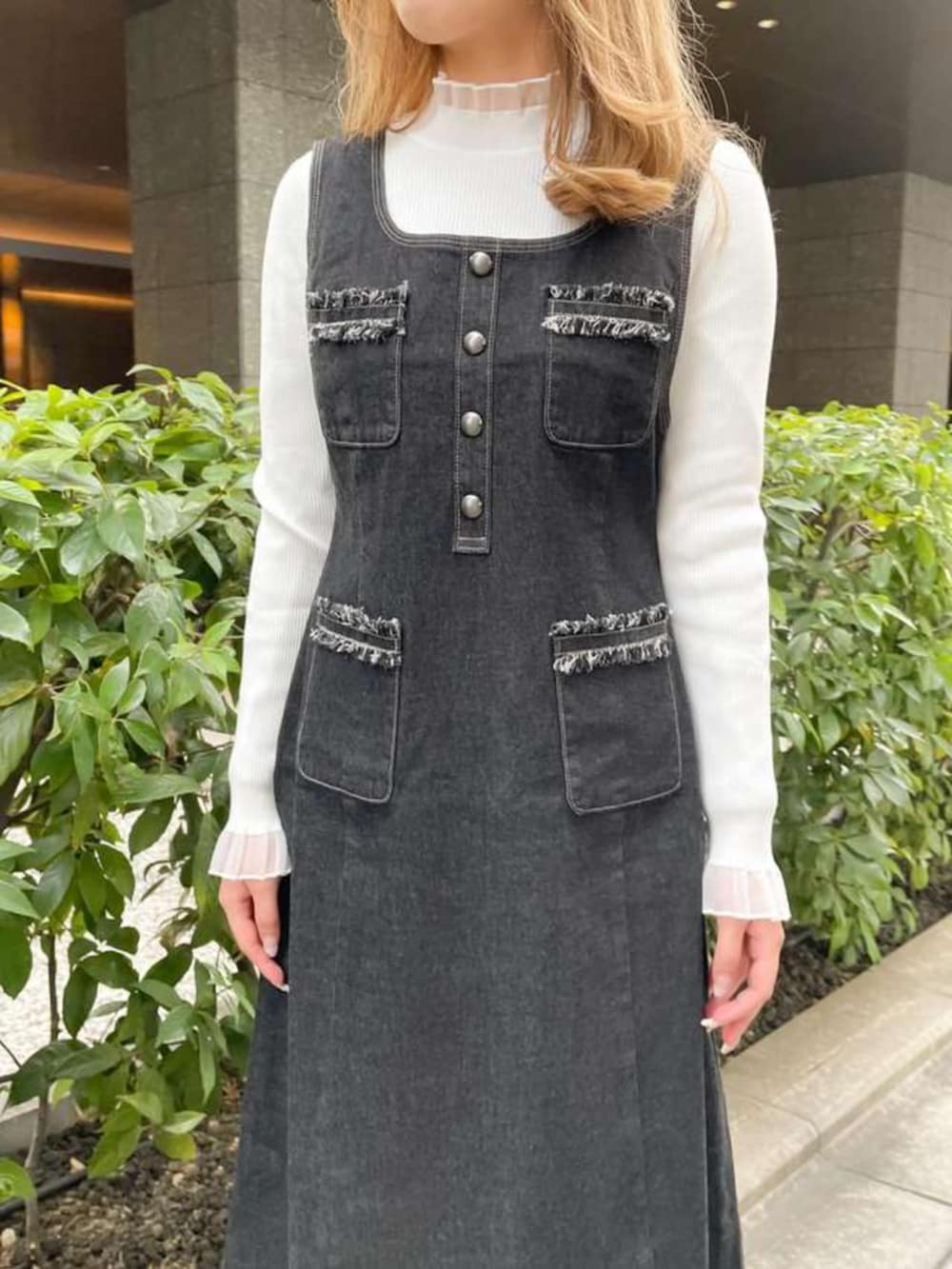 ホワイト系のニット/セーター、ブルー系のジャンパースカートを着用したレディースの冬コーディネートの2枚目の写真