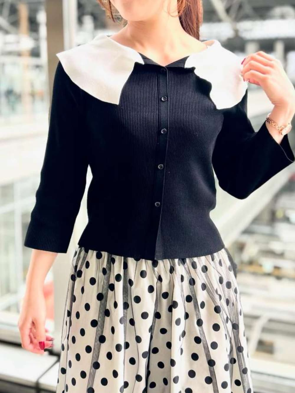 ホワイト系のスカート、ブラック系のニット/セーターを着用したレディースの春コーディネートの2枚目の写真