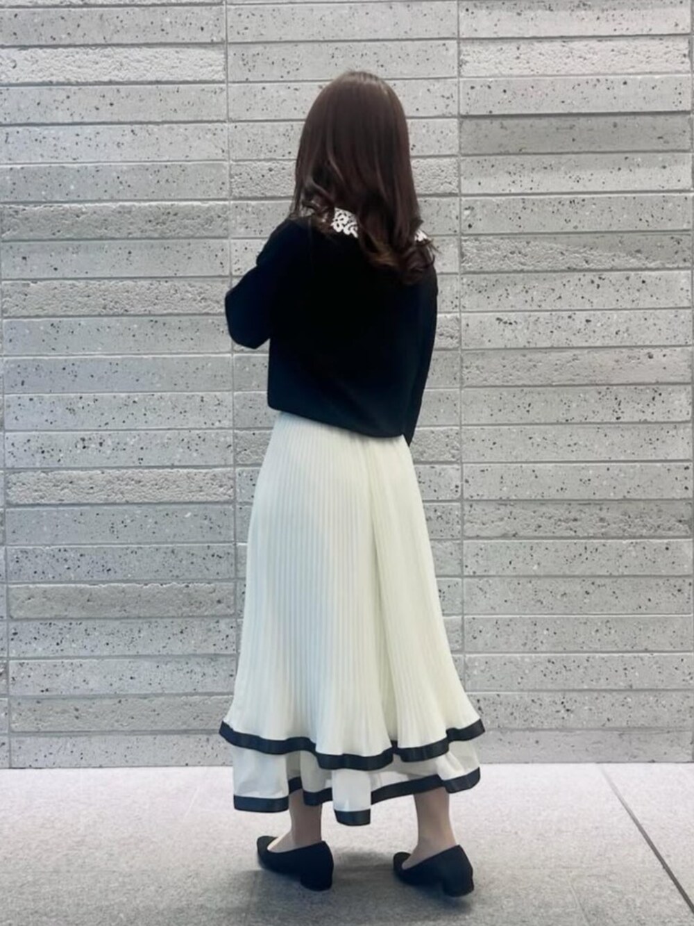 ホワイト系のスカート、ブラック系のニット/セーターを着用したレディースの冬コーディネートの4枚目の写真