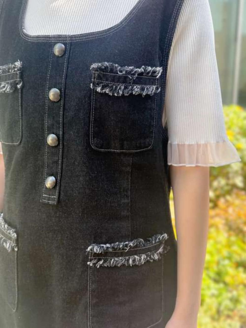 ブルー系のジャンパースカート、ホワイト系のニット/セーターを着用したレディースの春コーディネートの3枚目の写真