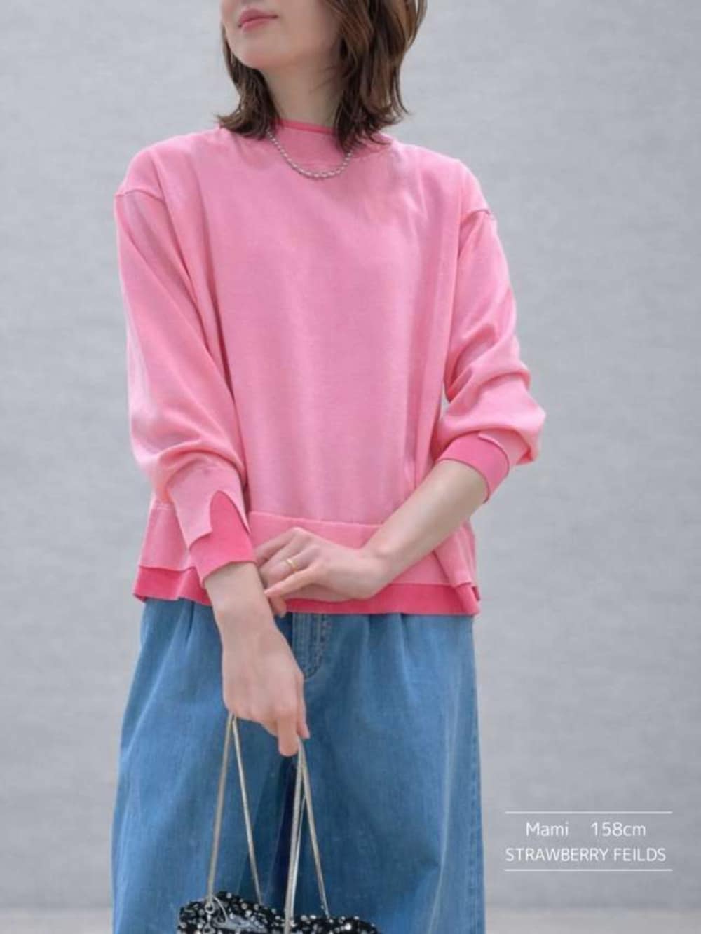 ブルー系のデニムパンツ、ピンク系のニット/セーターを着用したレディースの冬コーディネートの2枚目の写真