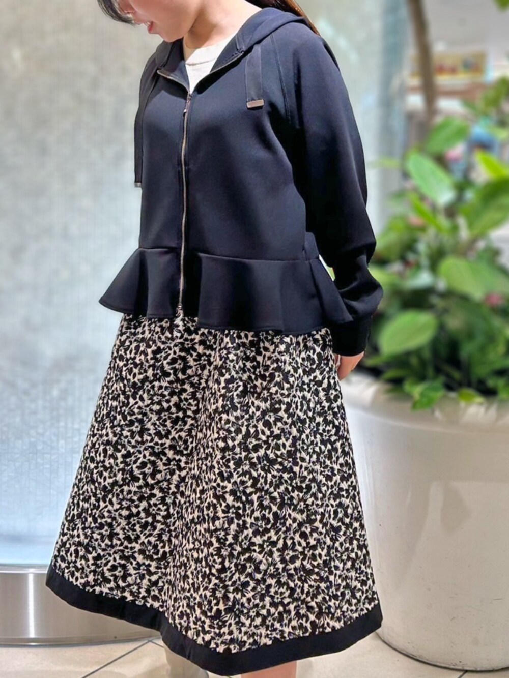 ホワイト系のスカート、ブラック系のパーカーを着用したレディースの秋コーディネートの2枚目の写真