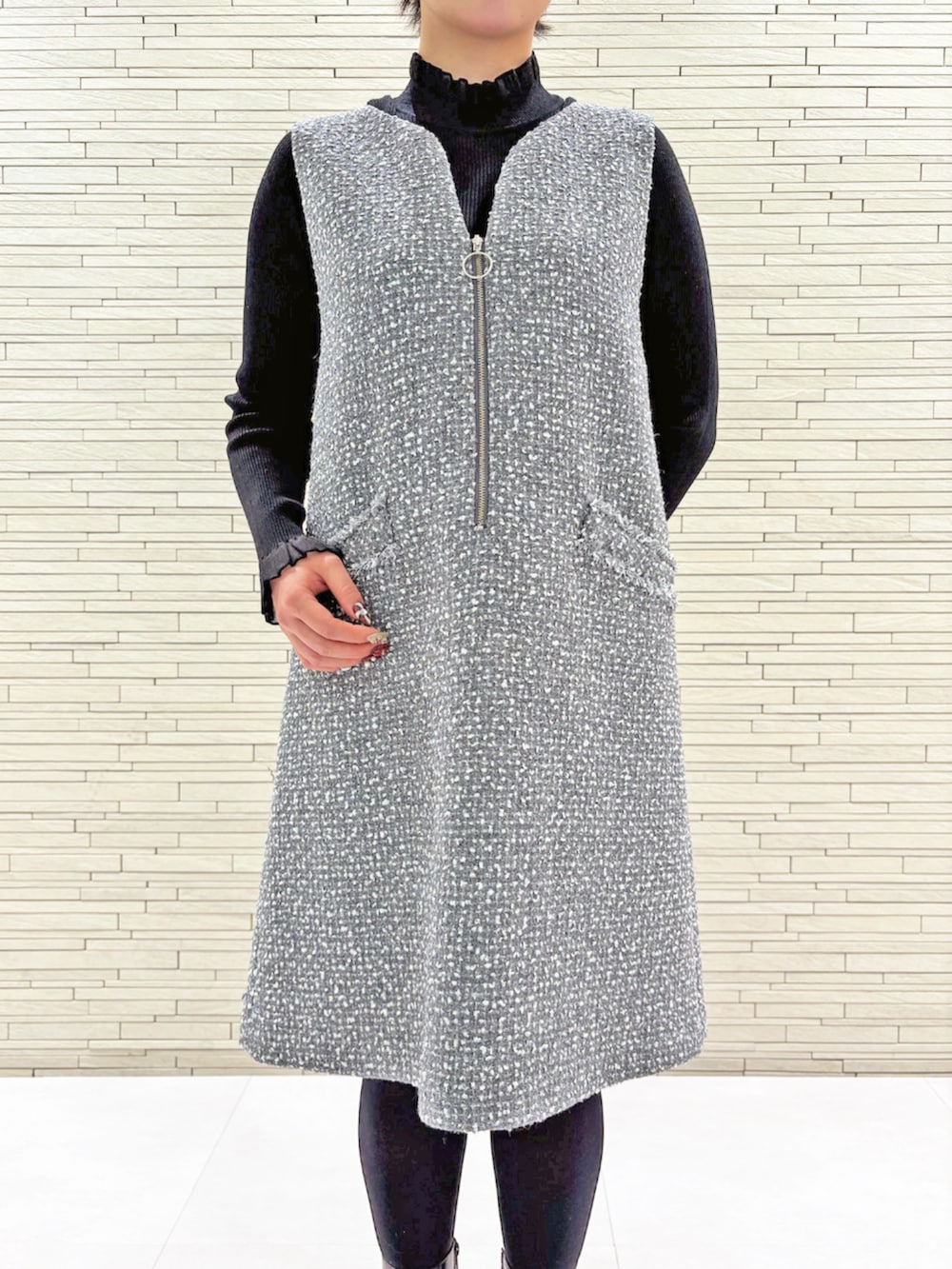 グレー系のジャンパースカート、ブラック系のニット/セーターを着用したレディースの冬コーディネートの4枚目の写真