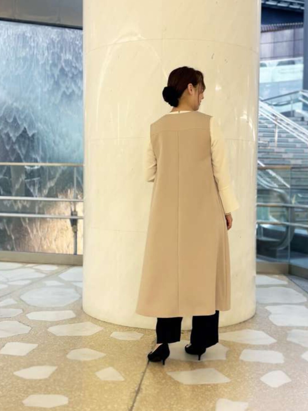 ホワイト系のシャツ/ブラウス、ベージュ系のジャンパースカート、ブラック系のスラックスを着用したレディースの冬コーディネートの2枚目の写真