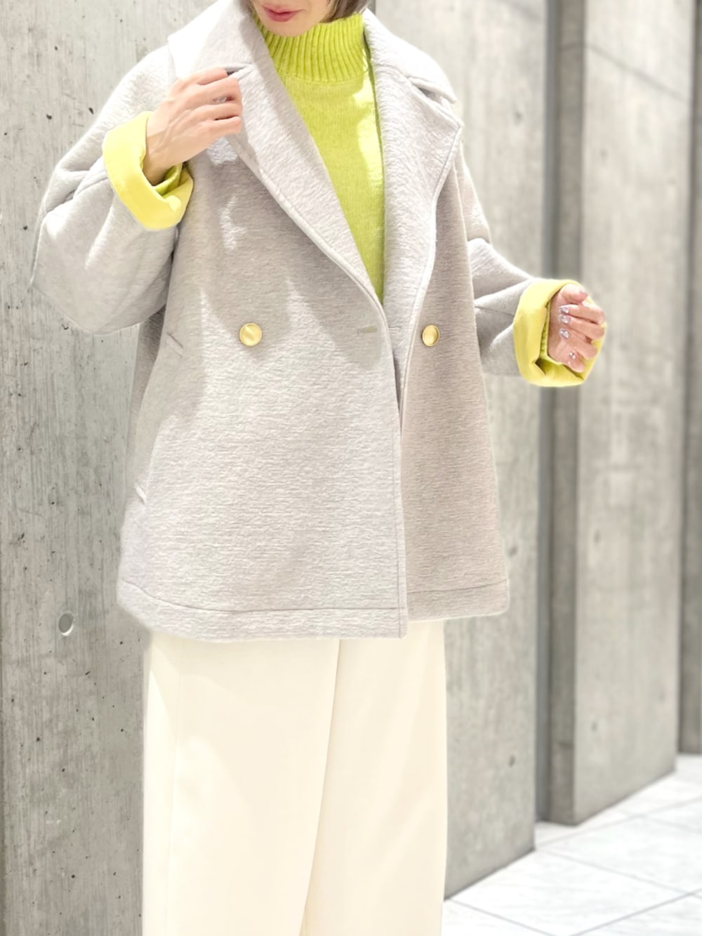 グレー系のその他アウター、イエロー系のニット/セーター、ホワイト系のその他パンツを着用したレディースの秋コーディネートの2枚目の写真