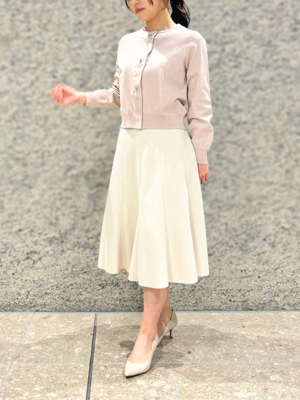 ピンク系のカーディガン/ボレロ、ベージュ系のスカートを着用したレディースの冬コーディネートの2枚目の写真