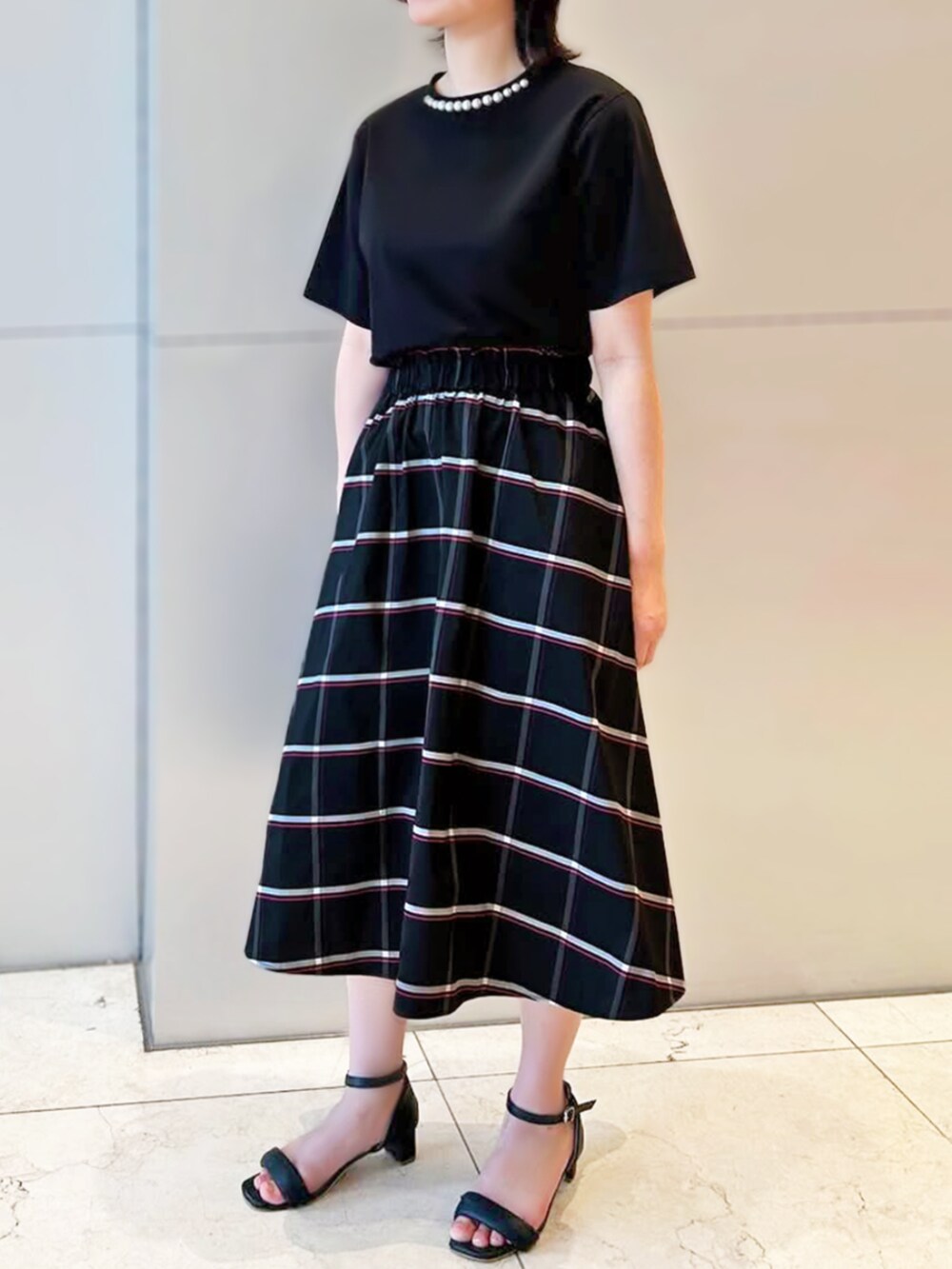 ブラック系のスカート、ブラック系のTシャツ/カットソーを着用したレディースの夏コーディネートの2枚目の写真