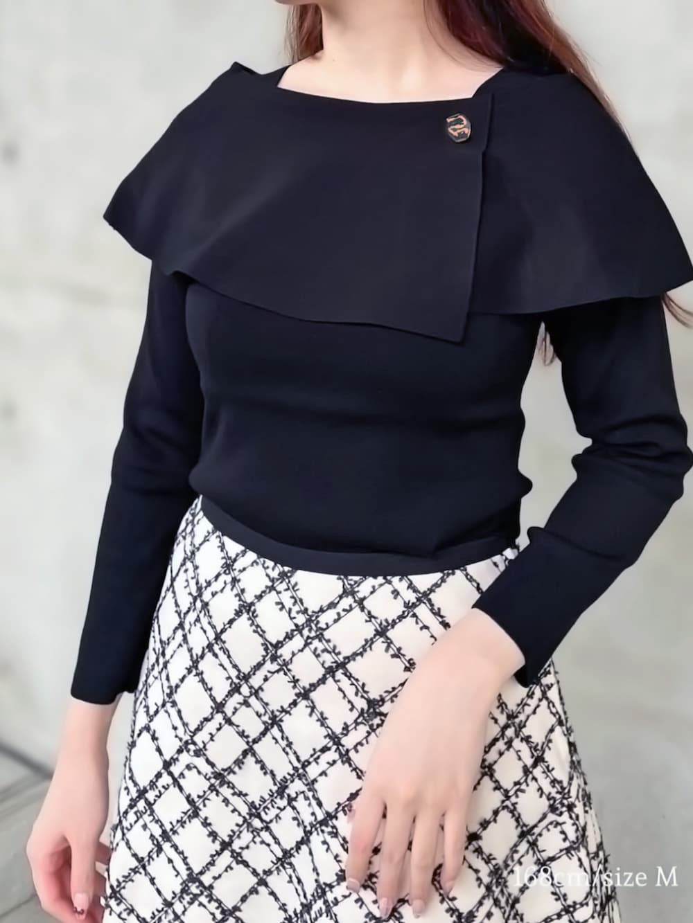 ブラック系のニット/セーター、ホワイト系のスカートを着用したレディースの秋コーディネートの3枚目の写真