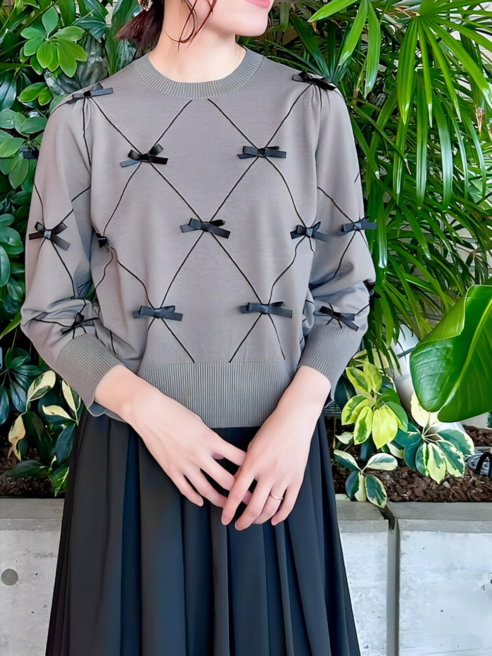 ブラック系のスカート、グレー系のニット/セーターを着用したレディースの秋コーディネートの3枚目の写真