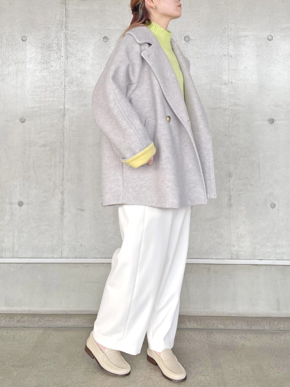 グレー系のその他アウター、イエロー系のニット/セーター、ホワイト系のその他パンツを着用したレディースの秋コーディネートの4枚目の写真